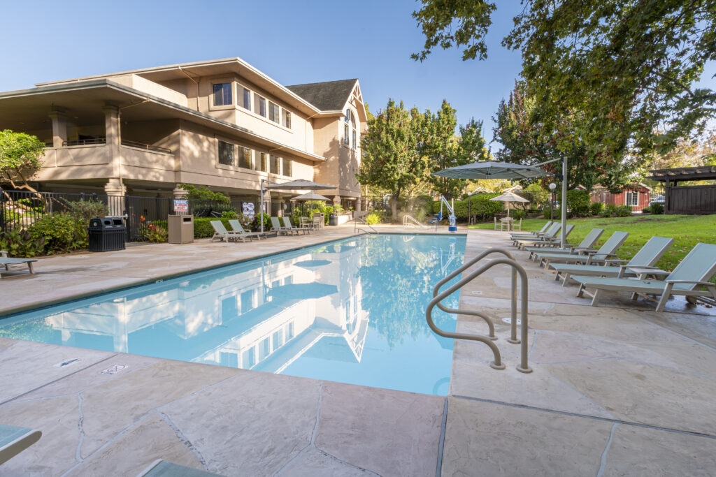 Pool surrounded by lounge chairs and umbrellas