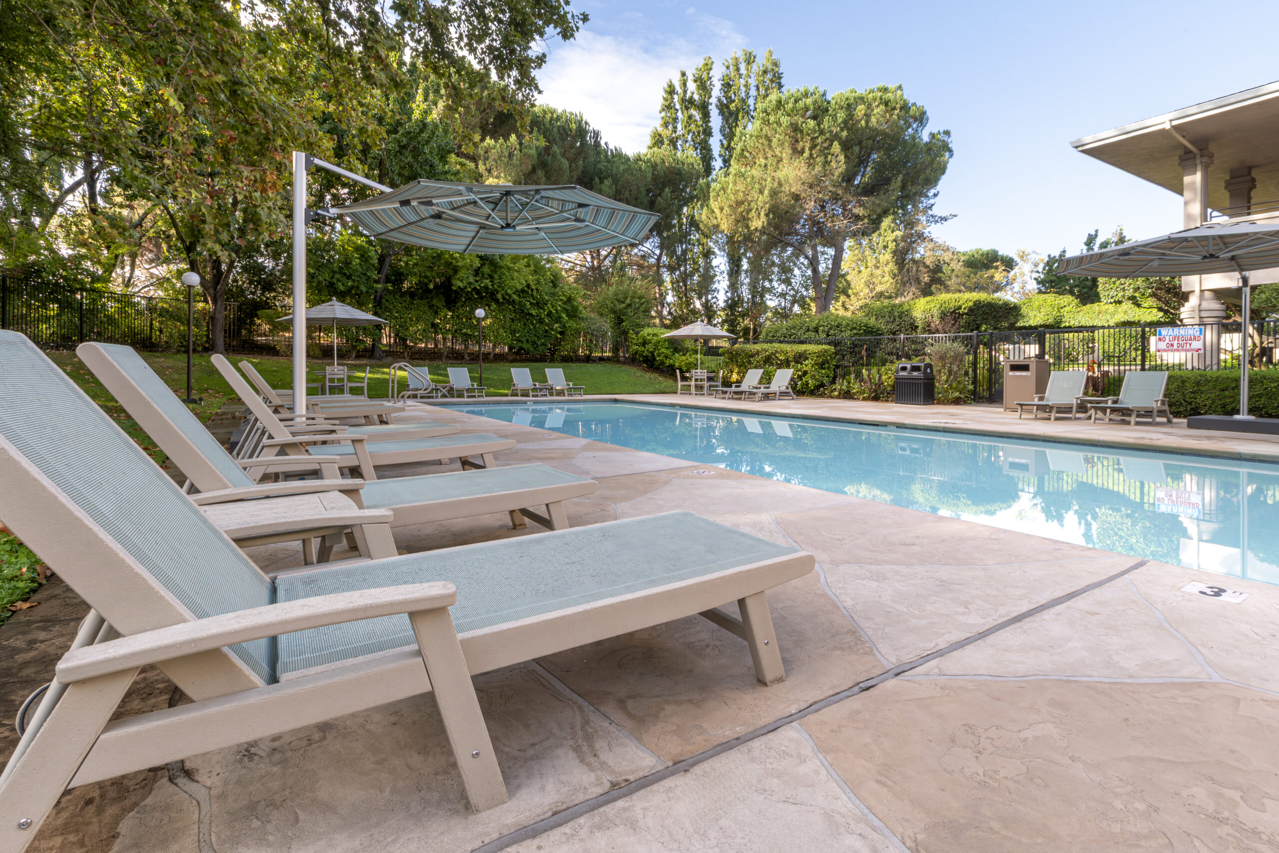 Outdoor pool with surrounding furniture and umbrella
