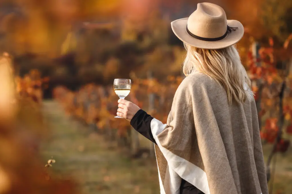 Female enjoying white wine in autumn season
